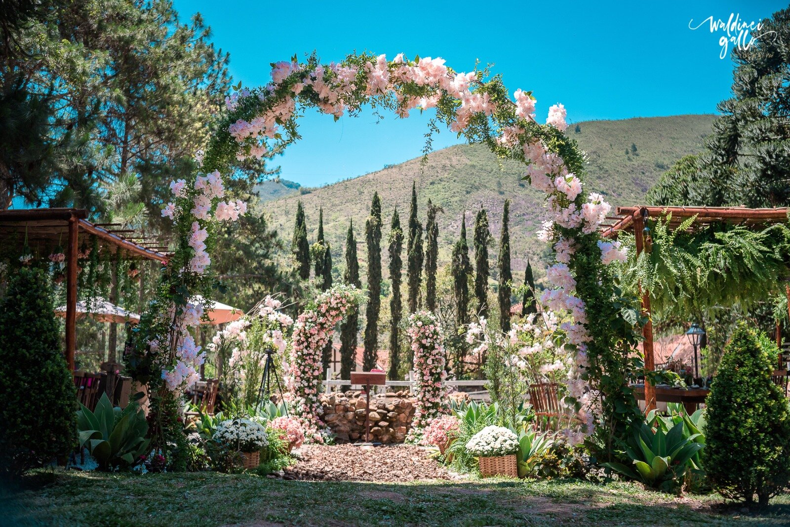 Jardim de cerimônia com arco floral e cipreste