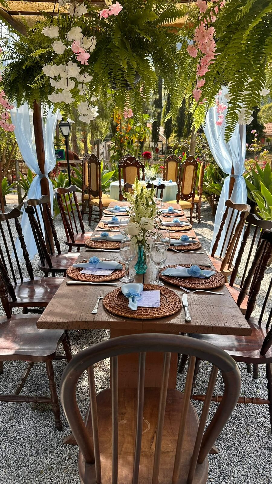 Mesa longa decorada com guardanapos azuis e samambaias