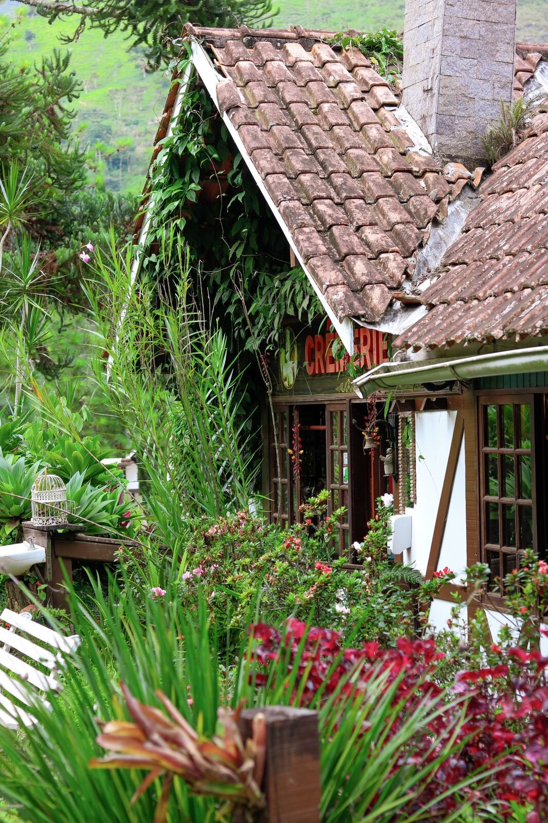 Casa Cremerie envolta em vegetação e flores